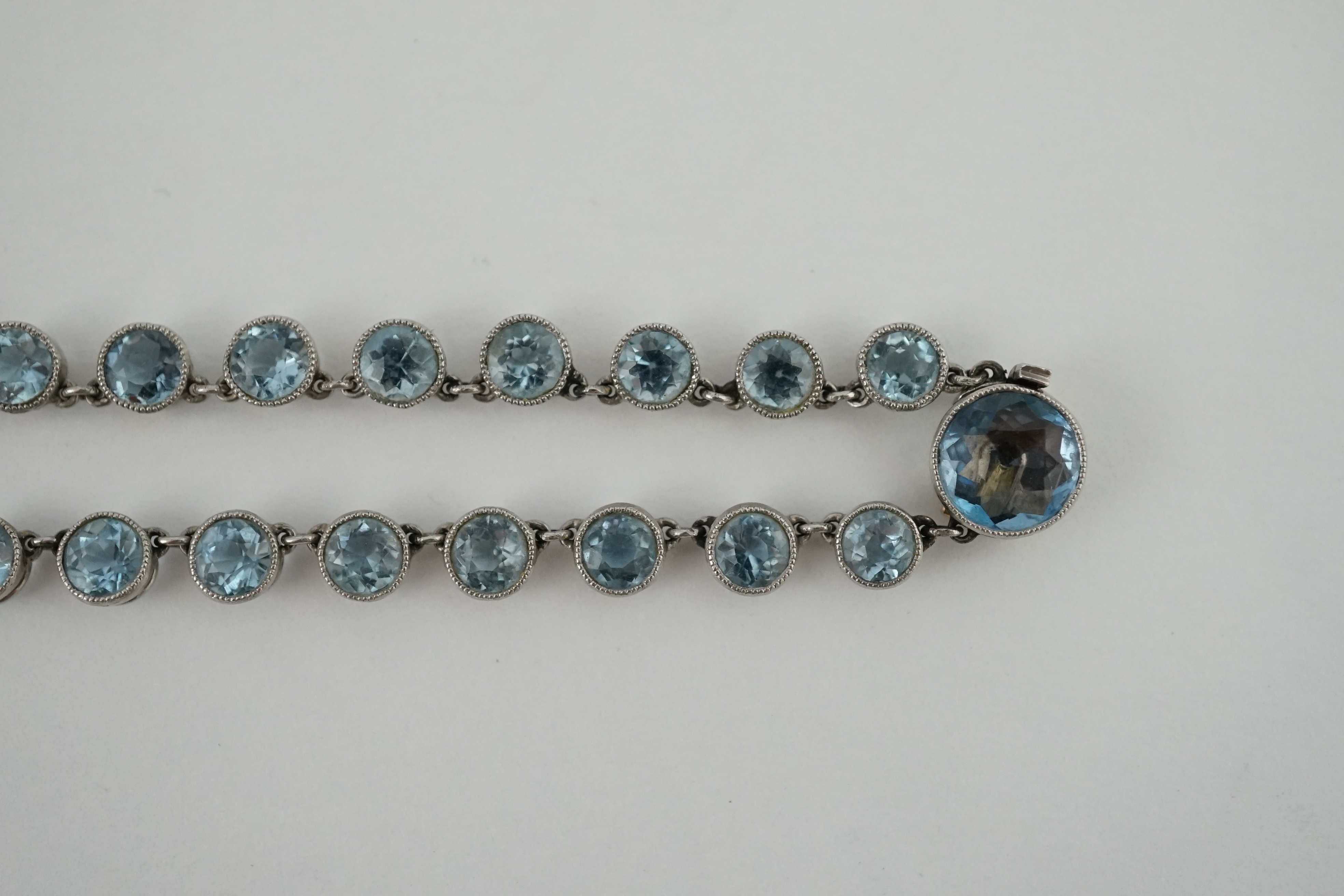 A Belle Epoque platinum and millegrain set graduated aquamarine necklace